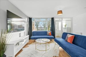 un salon avec un canapé bleu et une télévision dans l'établissement Cosy 3 Bedroom with Free Parking, Garden and Smart TV with Netflix by Yoko Property, à Coventry