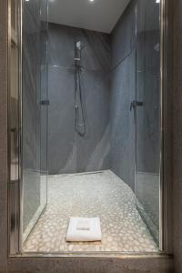 La salle de bains est pourvue d'une douche avec une porte en verre. dans l'établissement BePlace Apartments in Duomo, à Milan
