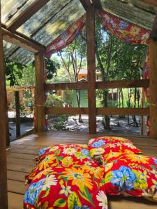 2 almohadas en una terraza de madera con dosel en Pousada Quintessência, en Arraial d'Ajuda