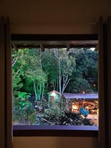 una ventana con vistas al jardín en Pousada Quintessência, en Arraial d'Ajuda