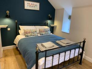 a bedroom with a bed with blue walls at The Barn at Pentregaer Ucha, with tennis court and lake in Oswestry