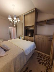 a bedroom with a large bed and a chandelier at Apartmani Tip-Top in Tivat