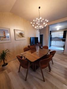 une salle à manger avec une table, des chaises et un lustre dans l'établissement Apartmani Tip-Top, à Tivat