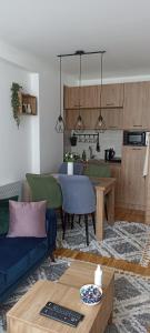 a living room with a blue couch and a kitchen at Apartman MonTanja Kopaonik, u hotelu Kraljevi Čardaci in Kopaonik