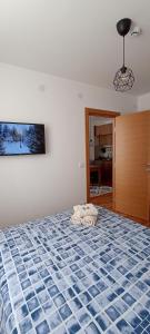 a bedroom with a bed with a blue and white comforter at Apartman MonTanja Kopaonik, u hotelu Kraljevi Čardaci in Kopaonik +33 photos