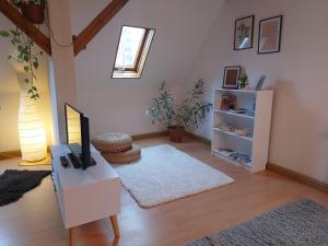 ein Wohnzimmer mit einem TV und einem Tisch in der Unterkunft Ferienwohnung am Salzsee in Bad Windsheim + 9 Fotos