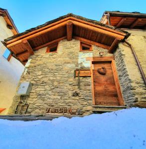 a stone building with a wooden door on it at CHALET DI MONTAGNA, Valtournenche-Cervinia in Valtournenche