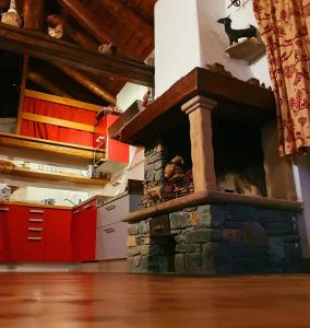 a stone fireplace in a kitchen with red cabinets at CHALET DI MONTAGNA, Valtournenche-Cervinia in Valtournenche