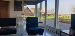 Pokój ze stołem i krzesłami oraz dużym oknem w obiekcie Ermerhoek, in de Hof w mieście Erm
