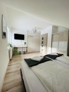 a white bedroom with a large bed and a desk at Pokoje pod Szyndzielnią in Bielsko-Biala