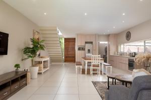a kitchen and living room with a table and chairs at Zimbali Wedge Unit 42 in Ballito