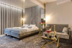 a bedroom with a bed and a couch at Hotel & Spa Biały Dom in Gliwice