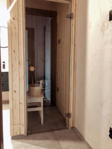 una puerta abierta a una habitación con silla y lavamanos en Jaszczurowa Apartament II, en Jaszczurowa