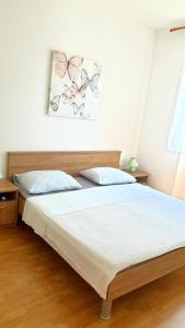 a bedroom with two beds and a painting on the wall at Apartmani Paron Šime in Seline