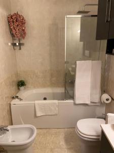 uma casa de banho com uma banheira, um WC e um lavatório. em AGM Suite Rome Airport FCO - Attico Parco Leonardo em Fiumicino