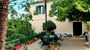 a patio with a table and chairs and plants at Apartmani Paron Šime in Seline