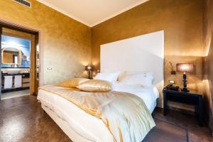 ein Schlafzimmer mit einem großen weißen Bett und einem Spiegel in der Unterkunft Alla Corte Delle Terme Resort in Viterbo