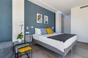 a bedroom with a large bed and a blue wall at Flamingo's way Cagliari in Cagliari