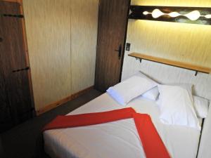 Un dormitorio con una cama con una manta roja. en Manoir 3 appt Les Gets, en Les Gets