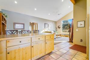 a kitchen with wooden cabinets and a living room at Rim Village D4 in Moab +17 photos