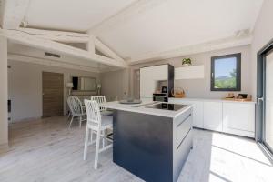 a kitchen with white cabinets and a counter top at Villa les trois J in Grimaud