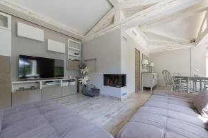 a living room with a bed and a tv at Villa Privée - Les Trois J - Charme & Bien-être in Grimaud