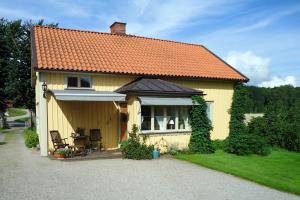 ein gelbes Haus mit orangefarbenem Dach in der Unterkunft Sjöbredareds Gård in Hökerum