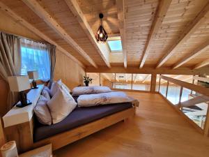 ein Schlafzimmer mit einem Bett in einem Zimmer mit Holzdecken in der Unterkunft Ferienwohnung Anna Salzburg Grödig in Grödig