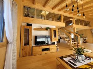 ein großes Wohnzimmer mit einem TV und einer Treppe in der Unterkunft Ferienwohnung Anna Salzburg Grödig in Grödig