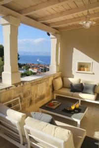 a living room with a couch and a table on a balcony at Villa Aries in Supetar