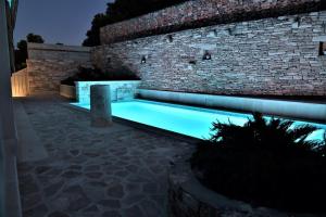 a swimming pool in front of a brick building at Villa Aries in Supetar