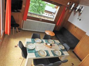 ein Tisch mit Tellern darauf in einem Raum mit einem Fenster in der Unterkunft Manoir 1 appt Les Gets in Les Gets