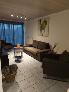 a living room with a couch and a table at appartement rdc plein centre avec terrasse in Visé