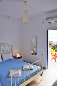 a bedroom with a bed with a blue comforter at ONAR STUDIOS MILOS Junior in Adamantas