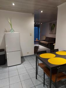 a living room with a table and a refrigerator at appartement rdc plein centre avec terrasse in Visé
