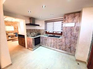 a large kitchen with a stone wall at Mahdia - Baghdadi - Laourient Apartments, restaurant, café in Mahdia