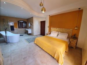 a bedroom with a large bed and a bath tub at Mahdia - Baghdadi - Laourient Apartments, restaurant, café in Mahdia