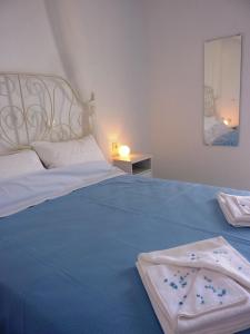 a large blue bed with a white headboard and white sheets at ONAR STUDIOS MILOS Junior in Adamantas