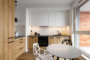 cocina con mesa blanca y sillas en Homewell Apartments Goplana en Poznan