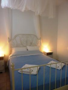 a bedroom with a bed with a blue blanket and white sheets at ONAR STUDIOS MILOS Junior in Adamantas