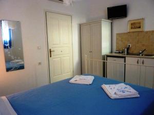 a bedroom with a blue table with two towels on it at ONAR STUDIOS MILOS Junior in Adamantas