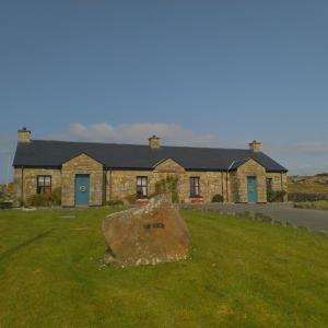 a house with a large rock in front of it at Creevy Cottages in Rossnowlagh