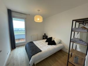 - une chambre avec un lit et une grande fenêtre dans l'établissement APPARTEMENT VANNES, à Vannes
