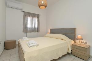 a bedroom with a bed and a night stand with a lamp at Calma Home in Naxos Chora