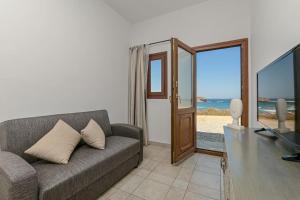 ein Wohnzimmer mit einem Sofa und einer Glasschiebetür in der Unterkunft Calma Home in Naxos Chora