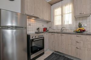 eine Küche mit einem Kühlschrank aus Edelstahl und einer Spüle in der Unterkunft Calma Home in Naxos Chora