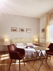 ミラノにあるAngela's Apartmentのベッドルーム1室(ベッド1台、椅子2脚、テーブル付)