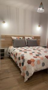 een slaapkamer met een groot bed en een kleurrijk dekbed bij MEET - AIRBUS - TRAMWAY in Aussonne