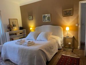 Un dormitorio con una cama blanca con toallas. en Domaine d'Angouire, en Moustiers-Sainte-Marie