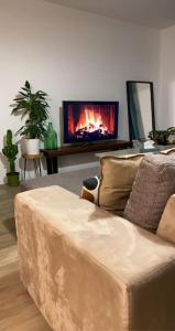 a living room with a couch and a flat screen tv at MEET - AIRBUS - TRAMWAY in Aussonne